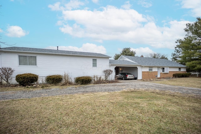 view of side of home with a carport and a yard