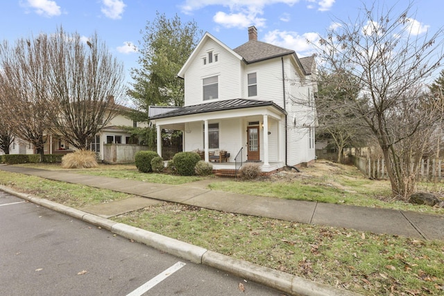 view of front of house with covered porch and a front lawn