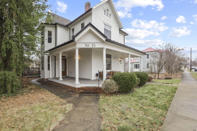 view of front of home with covered porch and a front lawn