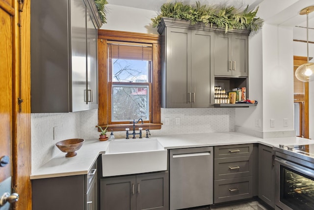 kitchen featuring sink, gray cabinetry, tasteful backsplash, hanging light fixtures, and stainless steel appliances