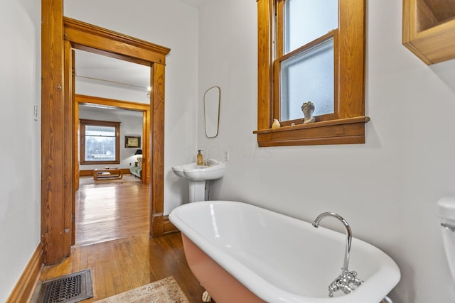 bathroom with hardwood / wood-style flooring and a bath