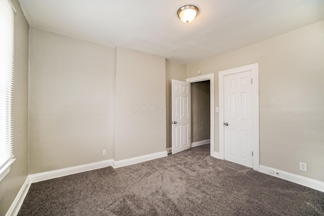 carpeted empty room with baseboards