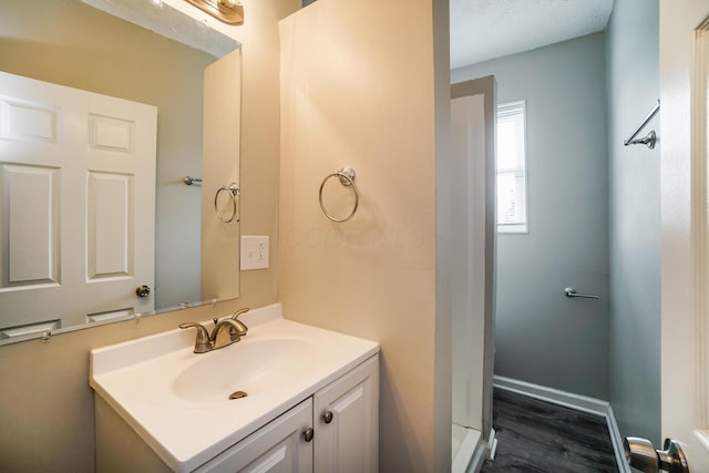 bathroom featuring wood finished floors, vanity, and baseboards