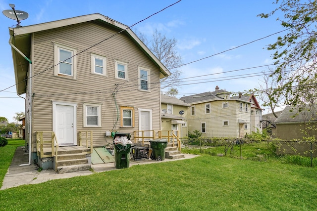 back of house featuring a yard and fence