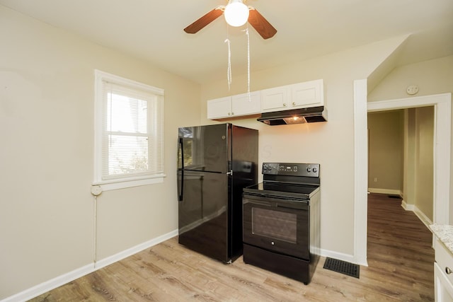 kitchen featuring light wood finished floors, visible vents, white cabinets, under cabinet range hood, and black appliances