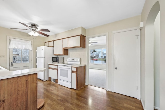 kitchen featuring ceiling fan, plenty of natural light, dark hardwood / wood-style floors, and white appliances