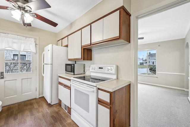 kitchen featuring crown molding, white appliances, dark wood-type flooring, ceiling fan, and white cabinets