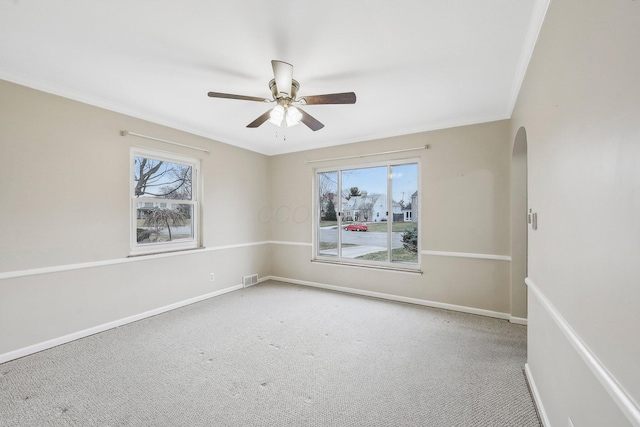 spare room featuring crown molding, ceiling fan, and carpet