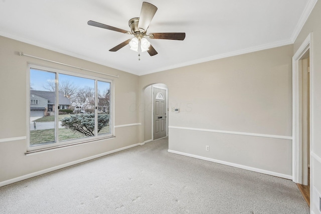 spare room with crown molding, ceiling fan, and carpet flooring