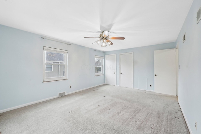 carpeted spare room with ceiling fan