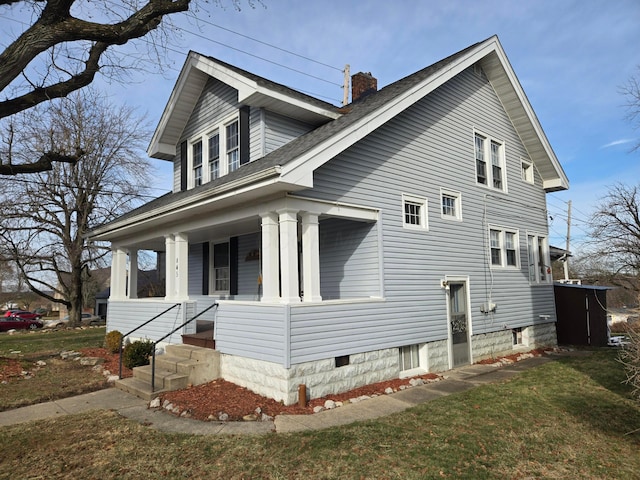 view of home's exterior featuring covered porch and a lawn