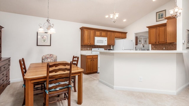 kitchen featuring brown cabinets, a sink, white appliances, a chandelier, and vaulted ceiling