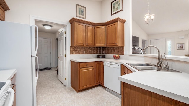 kitchen featuring a sink, white appliances, light floors, and brown cabinets