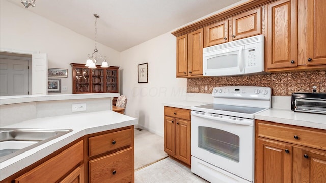 kitchen with white appliances, light countertops, and vaulted ceiling