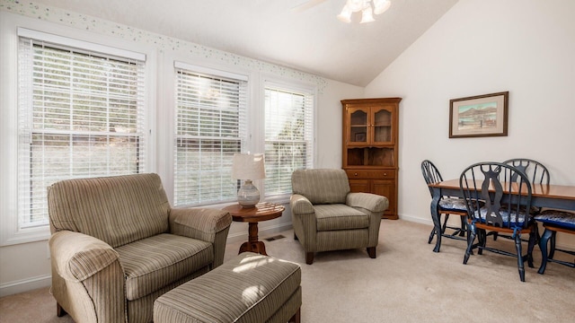 sitting room featuring light colored carpet, baseboards, lofted ceiling, and a ceiling fan