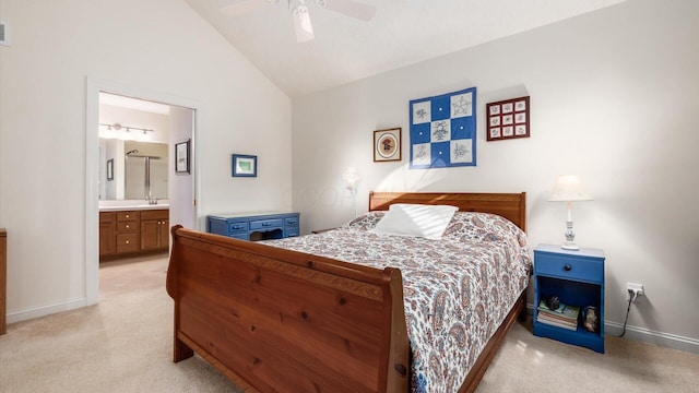 bedroom featuring light colored carpet, ensuite bathroom, baseboards, and vaulted ceiling