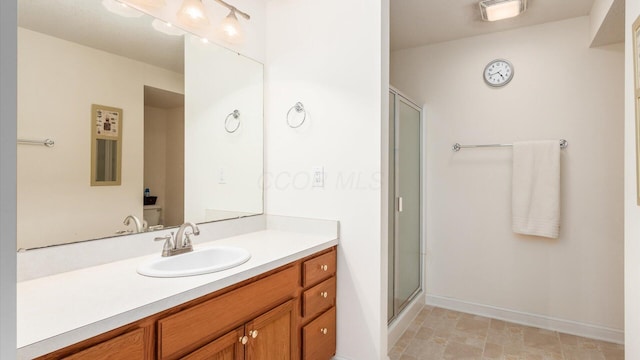 bathroom with visible vents, a stall shower, vanity, and baseboards