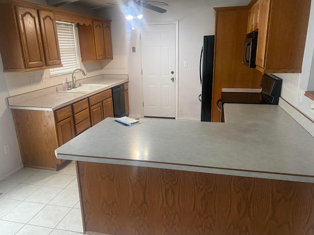 kitchen with light tile patterned flooring, kitchen peninsula, sink, and black appliances