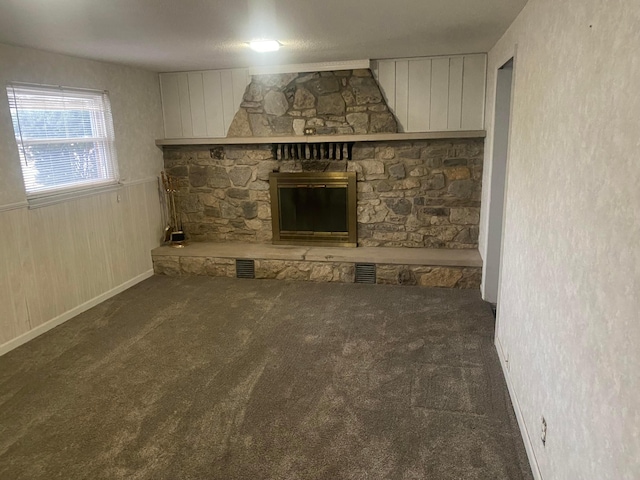 unfurnished living room featuring dark colored carpet and a fireplace