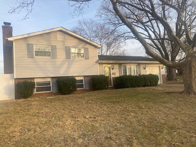 tri-level home with a garage and a front lawn