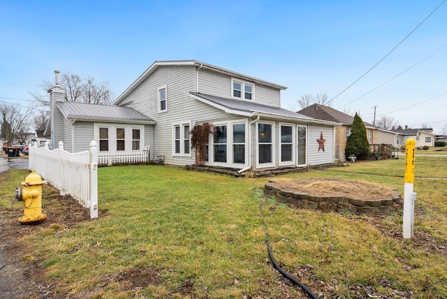 rear view of property with a lawn