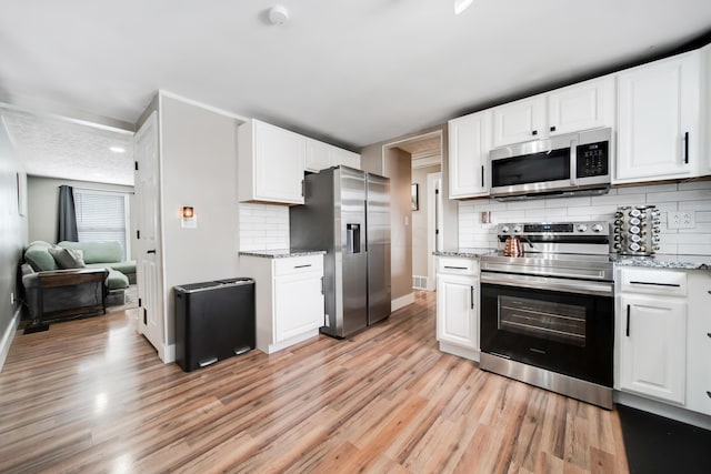 kitchen with stainless steel appliances, light wood-type flooring, and white cabinets