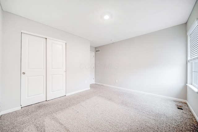 unfurnished bedroom with carpet flooring and a closet