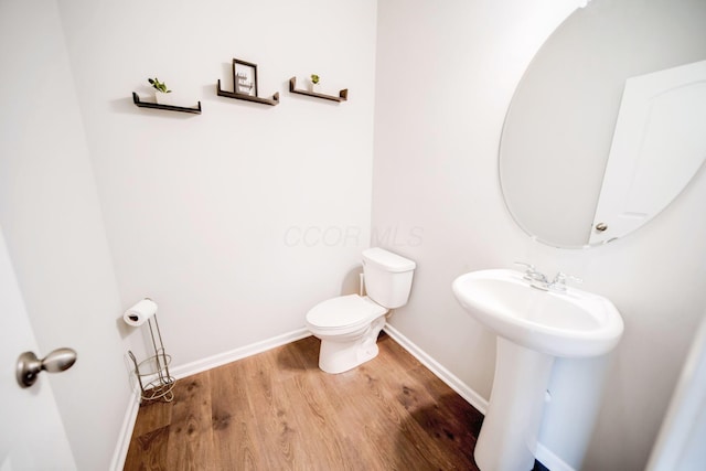 bathroom with hardwood / wood-style floors, sink, and toilet