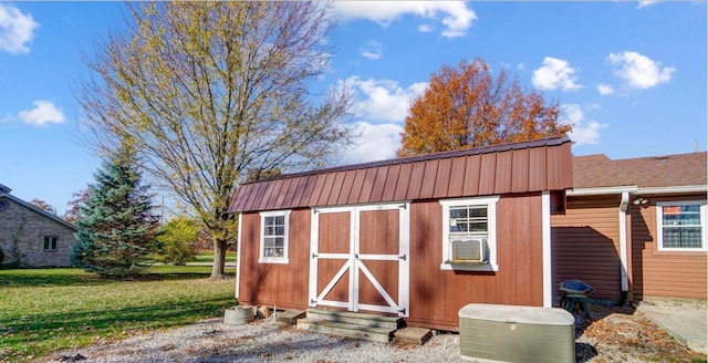 view of outbuilding featuring a yard and cooling unit