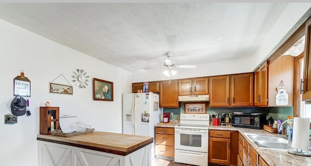 kitchen with butcher block counters, sink, white appliances, ceiling fan, and a textured ceiling