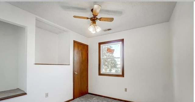 carpeted spare room with ceiling fan