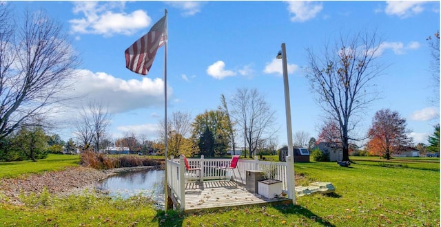 dock area with a deck with water view and a yard