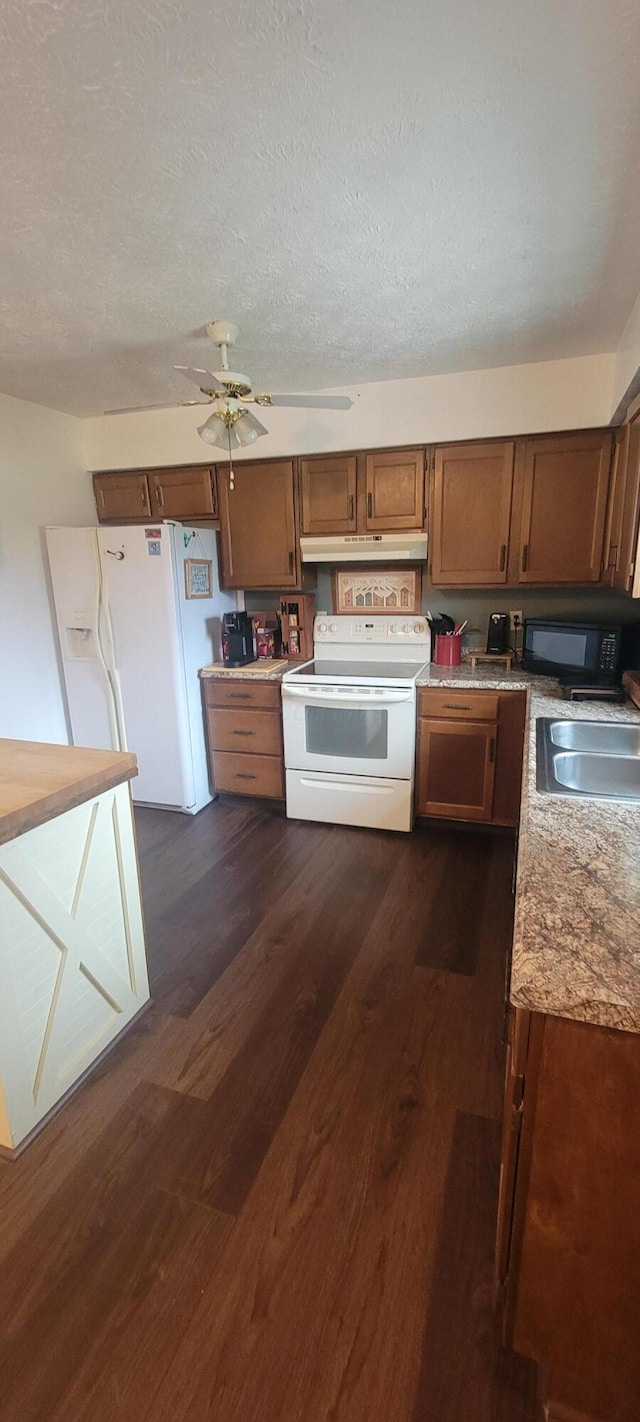 kitchen with dark hardwood / wood-style floors, sink, white appliances, ceiling fan, and a textured ceiling