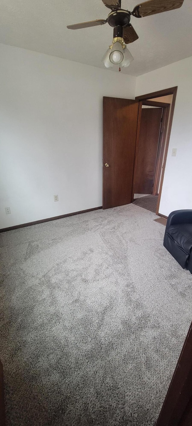 unfurnished bedroom featuring carpet floors, a closet, and ceiling fan