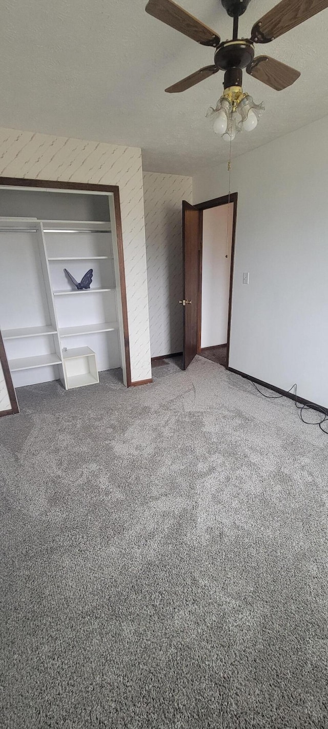 unfurnished bedroom with ceiling fan, carpet floors, and a textured ceiling