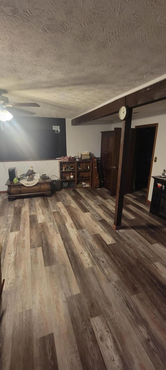 interior space with ceiling fan, wood-type flooring, and a textured ceiling