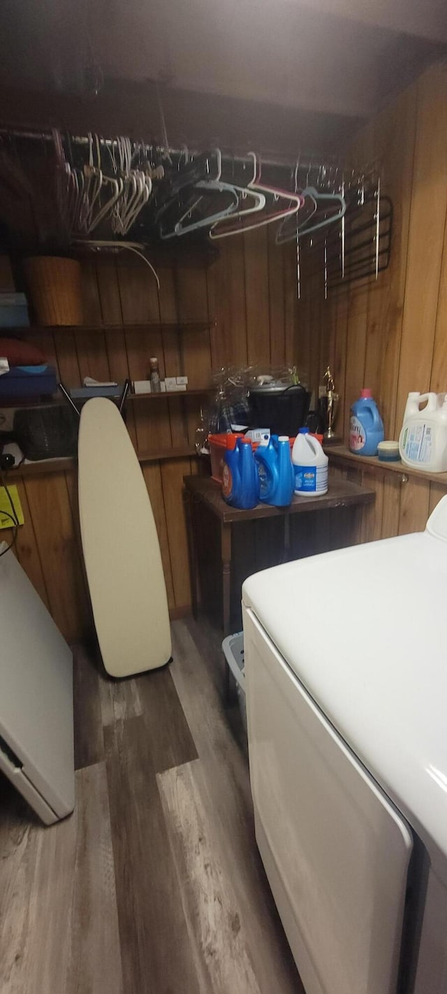 basement with washer / clothes dryer, hardwood / wood-style flooring, and wood walls