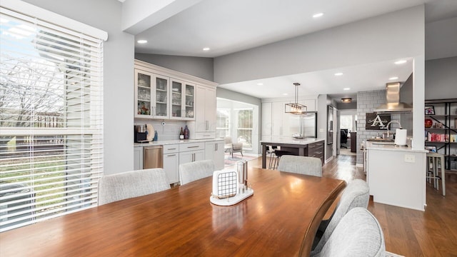 dining room featuring hardwood / wood-style flooring, lofted ceiling, and sink