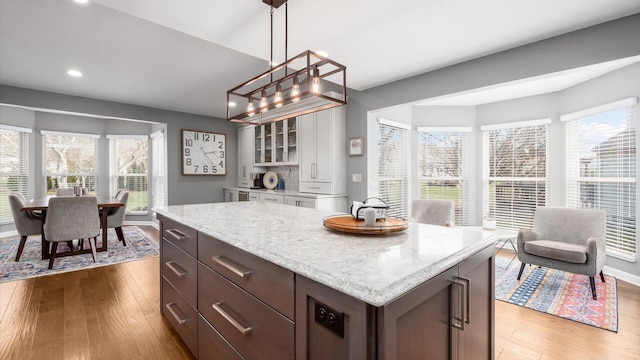 kitchen featuring hardwood / wood-style floors, a kitchen island, and a wealth of natural light