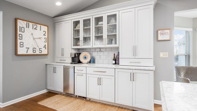 bar featuring white cabinetry, light stone countertops, light hardwood / wood-style floors, and decorative backsplash