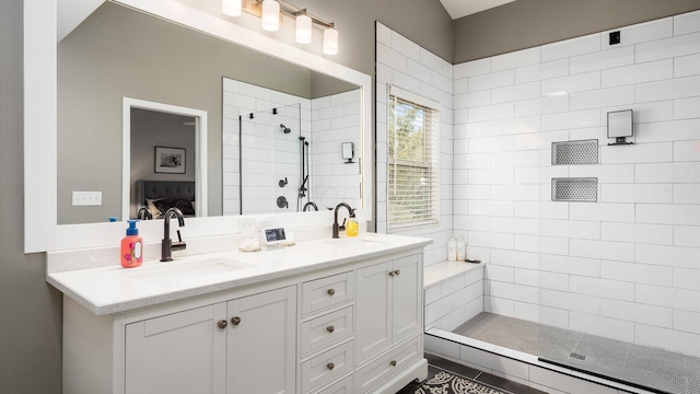 bathroom with vanity and a tile shower