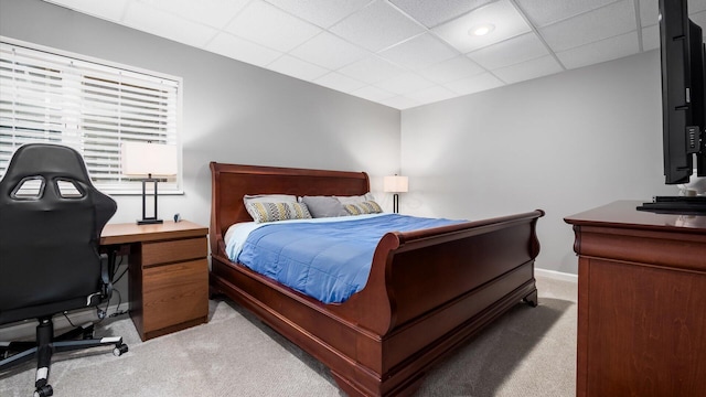 carpeted bedroom with a paneled ceiling