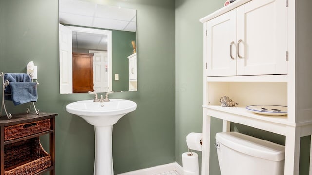 bathroom featuring toilet and a drop ceiling