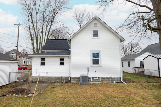 rear view of property featuring a yard and central AC unit