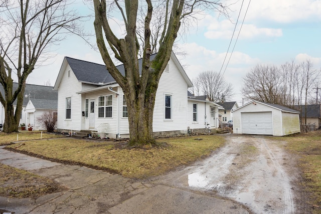 view of front of house with a garage, an outdoor structure, and a front yard