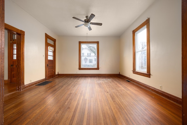 spare room featuring hardwood / wood-style flooring, plenty of natural light, and ceiling fan