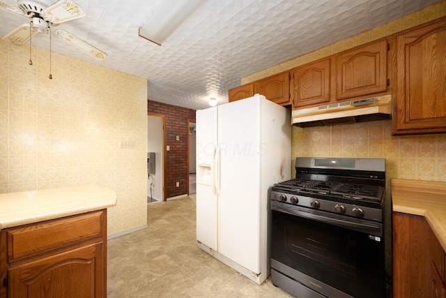 kitchen featuring ceiling fan, stainless steel range with gas cooktop, and white refrigerator with ice dispenser