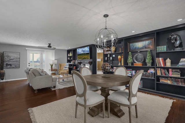 dining space with a chandelier, a textured ceiling, baseboards, and wood finished floors