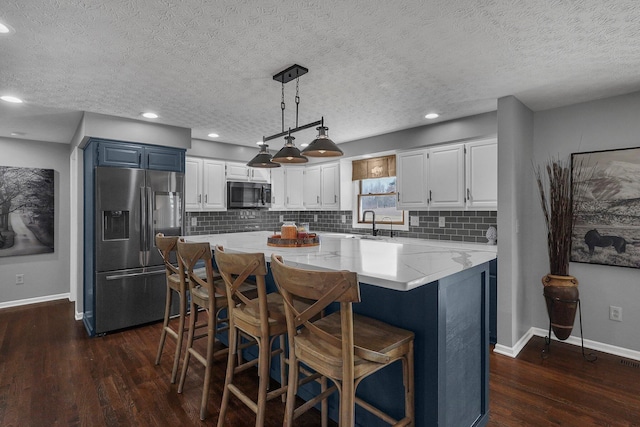 kitchen featuring tasteful backsplash, a kitchen island, stainless steel appliances, and dark wood-style flooring