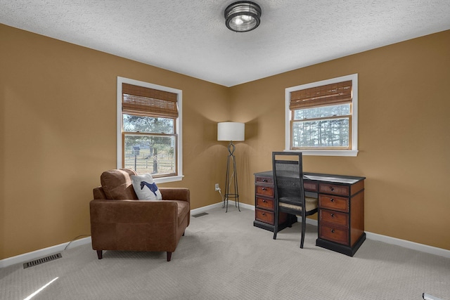 office area with a textured ceiling, carpet, visible vents, and baseboards